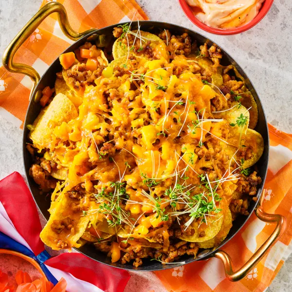 Oranje loaded nacho's met cheddar en kipgehakt