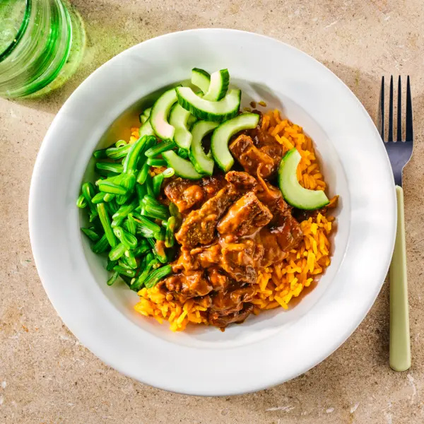 Snelle rendang met gele rijst en komkommer