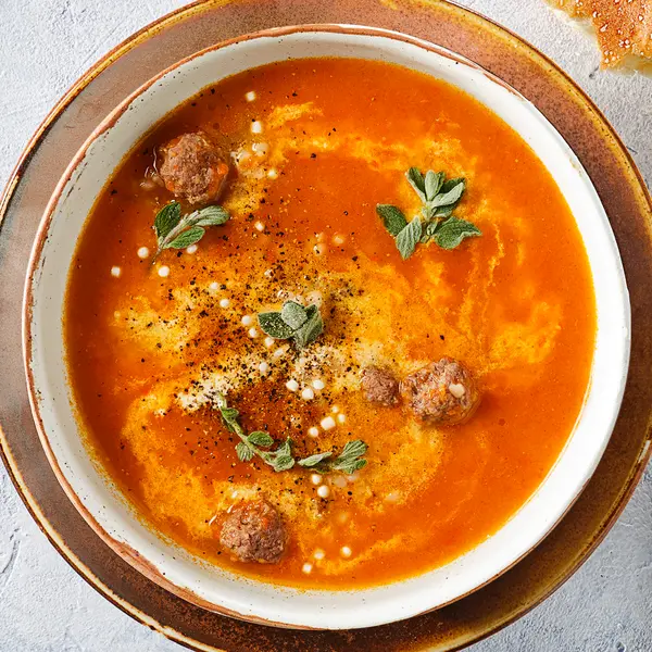 Romige tomaten-paprikasoep met parelcouscous en gehaktballetjes