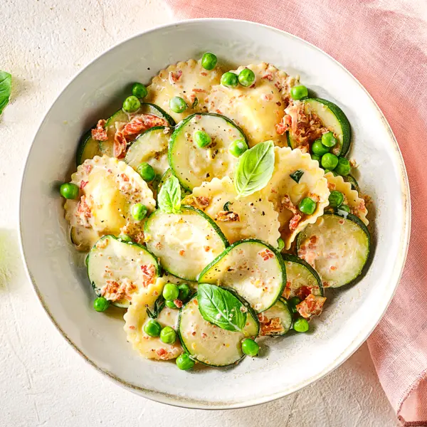 Romige ravioli met erwtjes en pancetta