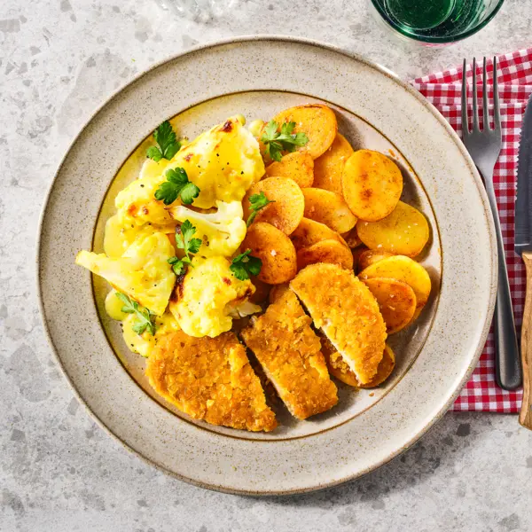 Schnitzel, aardappeltjes en bloemkool met kaassaus