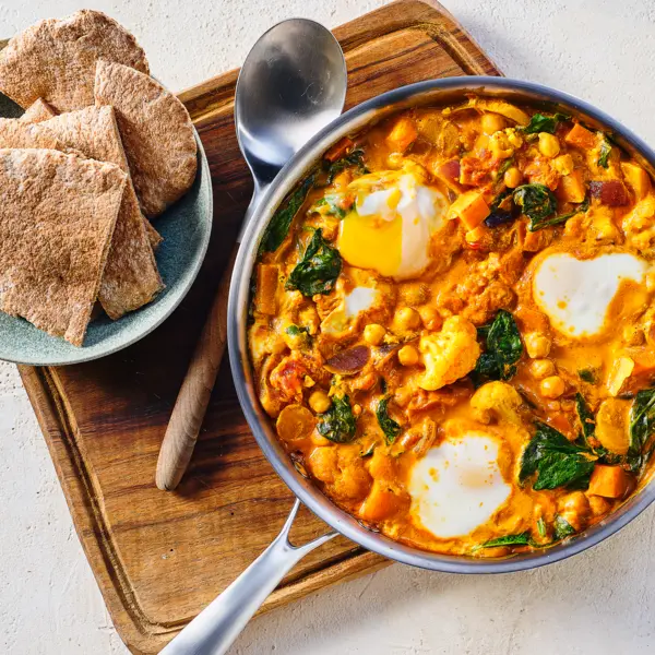 Milde tomatencurry met gepocheerde eitjes