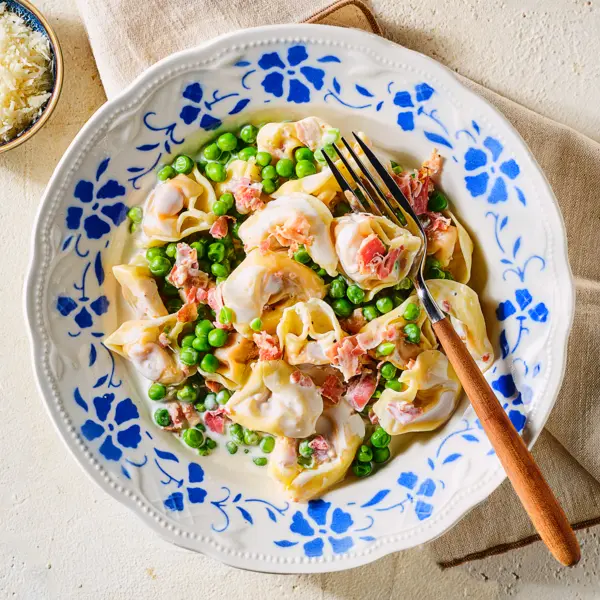 Romige tortellini met pancetta en erwtjes