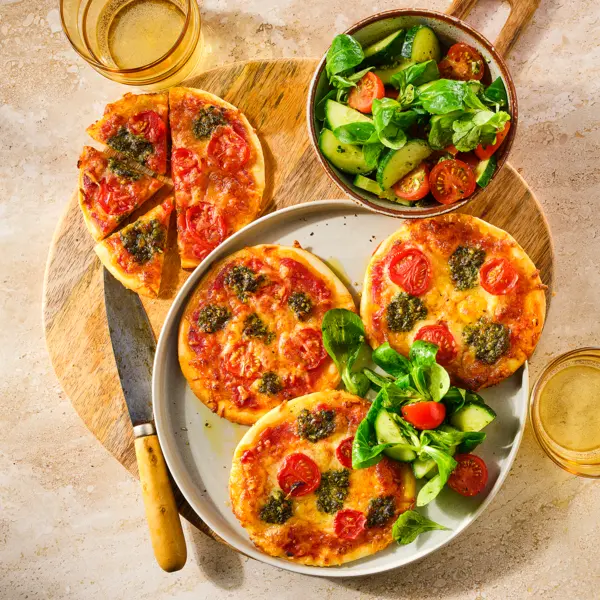 Mini pizza's met mozzarella en tomaat met pesto-komkommersalade