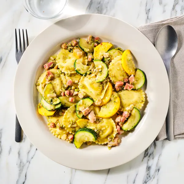 Ravioli met doperwten-muntsaus en pancetta en gele courgette