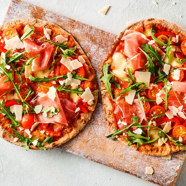 Platbroodpizza's met prosciutto en parmezaan