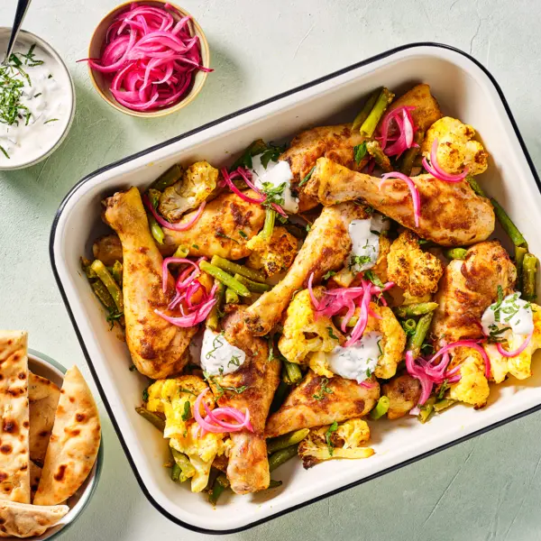 Traybake met kip-korma, groente en naan