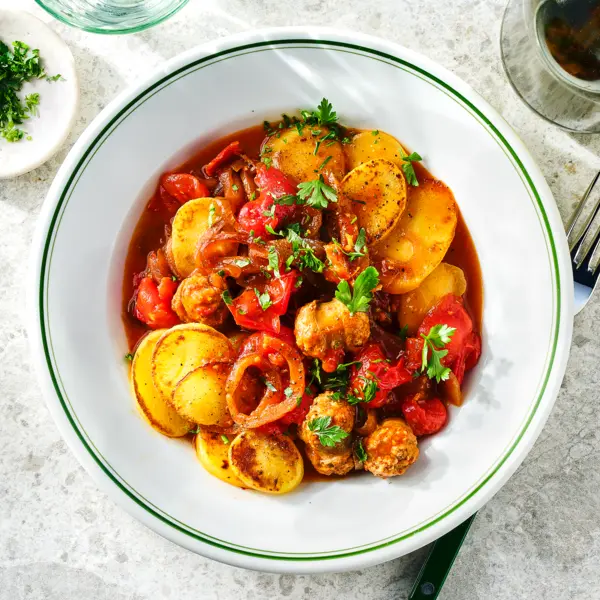 Gebakken aardappelen in tomatensaus met worst